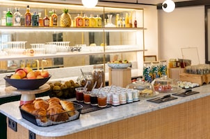 A breakfast buffet with various food items, beverages, and condiments.