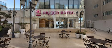 The Orchid Hotel with outdoor seating and potted plants.