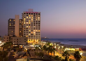 Un hotel con varios pisos, vista al mar y un restaurante McDonald's.