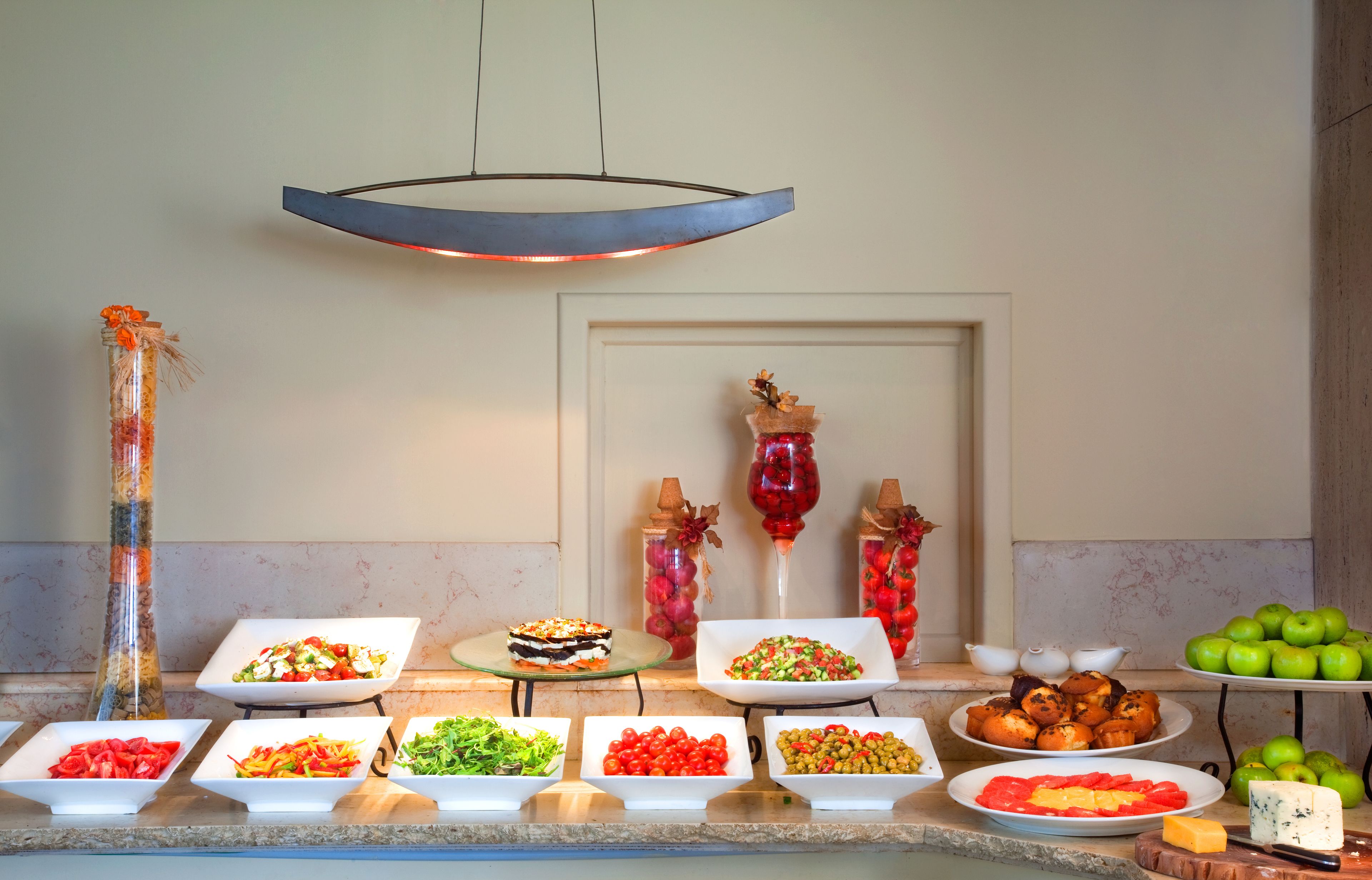 En buffet med diverse spiser samt et vinglas.