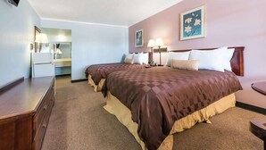 A hotel room with two beds, a dresser, a desk, and a television. - Relax Inn Mineral Wells (Mineral Wells)