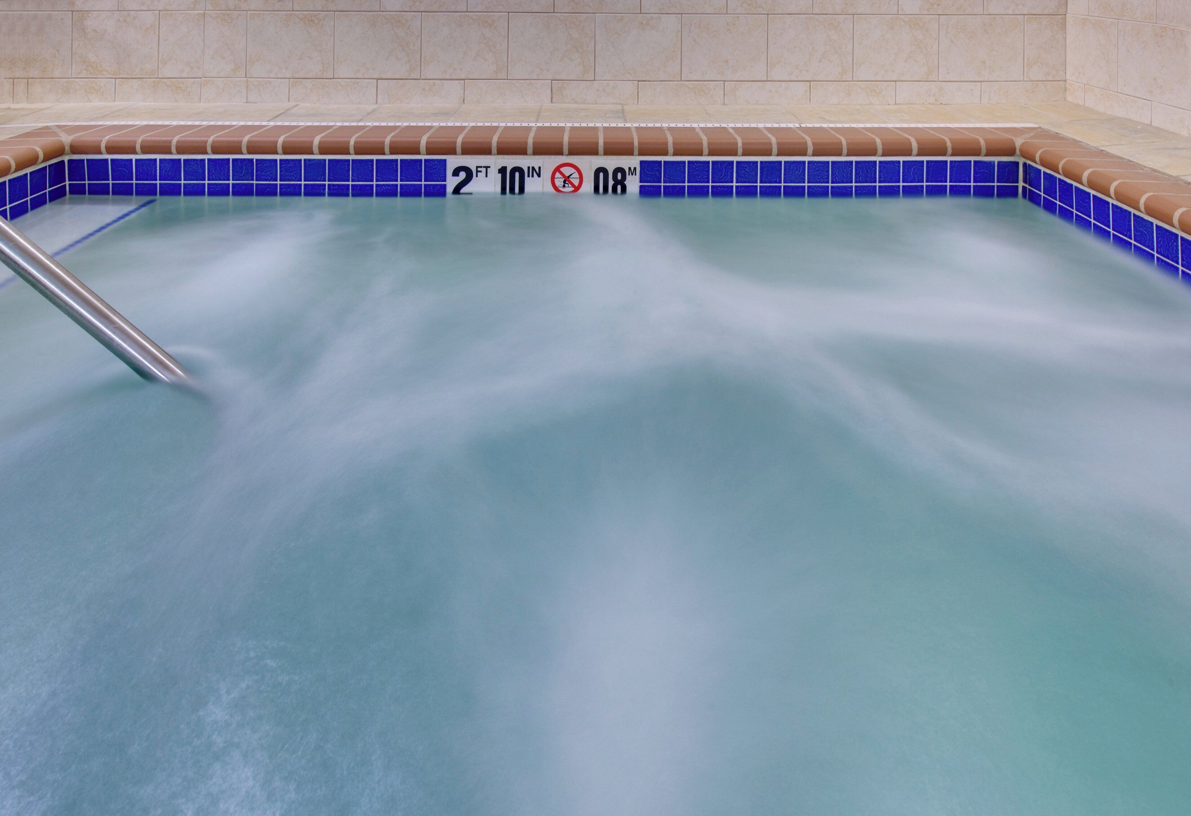 A hot tub with a depth marker indicating 2 feet 10 inches and a temperature of 98 degrees Fahrenheit.