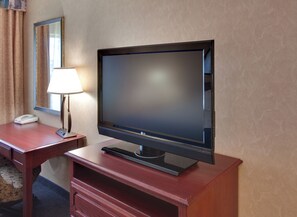 A hotel room with a flat-screen TV on a wooden stand, a desk with a lamp, and a telephone. - Holiday Inn Express Jamestown by IHG (Jamestown)