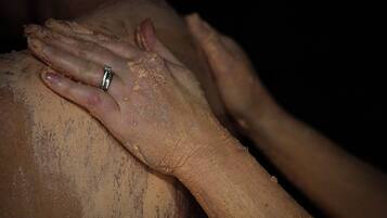 A close-up of hands, one wearing a ring, resting on a surface.