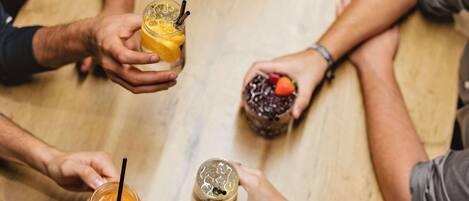 Un grupo de personas sosteniendo bebidas alrededor de una mesa.