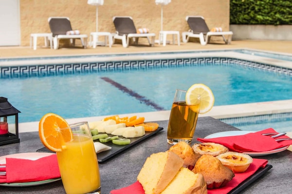 季节性开放的室外游泳池,池畔遮阳伞,日光浴躺椅