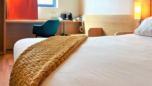 Ein Hotelzimmer mit einem großen Bett, einem Schreibtisch und einem Stuhl.
