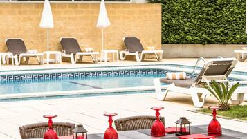 Piscina a l'aire lliure de temporada, para-sols i gandules