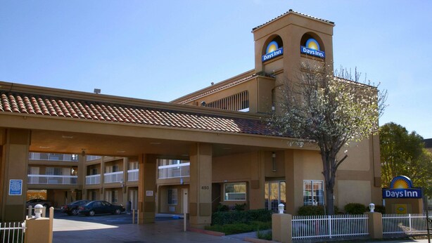 A Days Inn hotel with a central tower, multiple balconies, and a parking area.