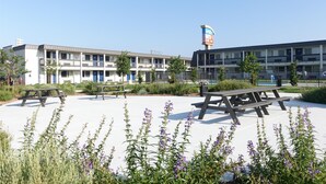 A building with multiple balconies and a flagpole. - Motel 6 Claremont, CA (Claremont)
