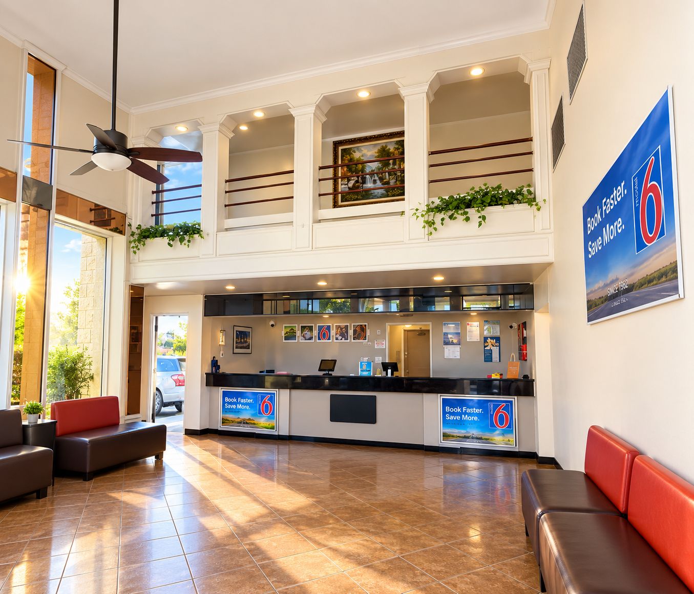 Un vestíbulo de hotel con una recepción, zona de estar y un amplio ventanal.
