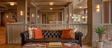 A spacious lobby with a leather sofa, a wooden coffee table, and a potted plant.
