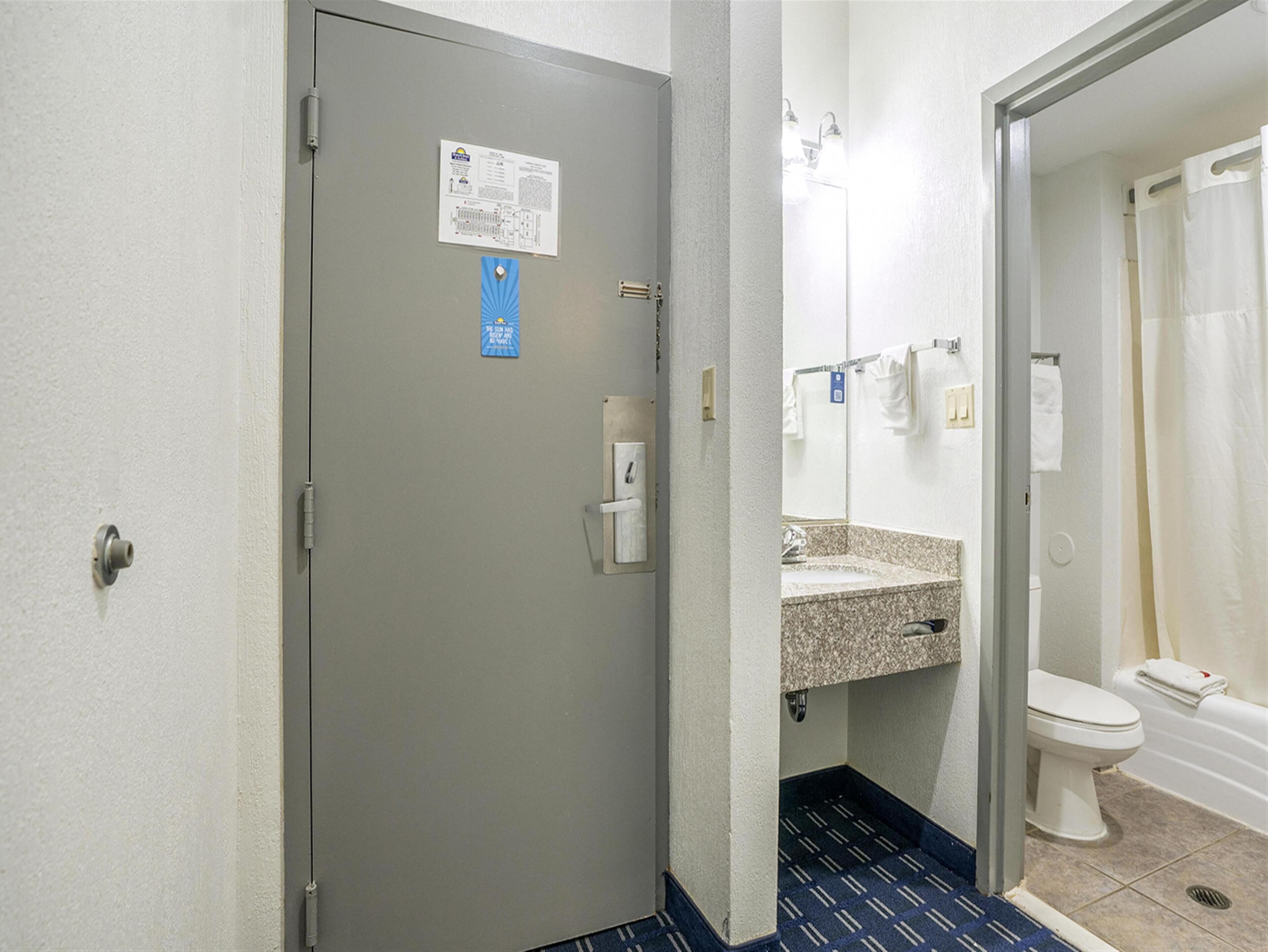 A hotel bathroom with a sink, toilet, and shower.