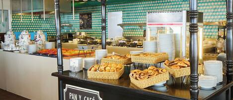 A buffet area with a sign reading "PAN Y CAFÉ EMPORIO".