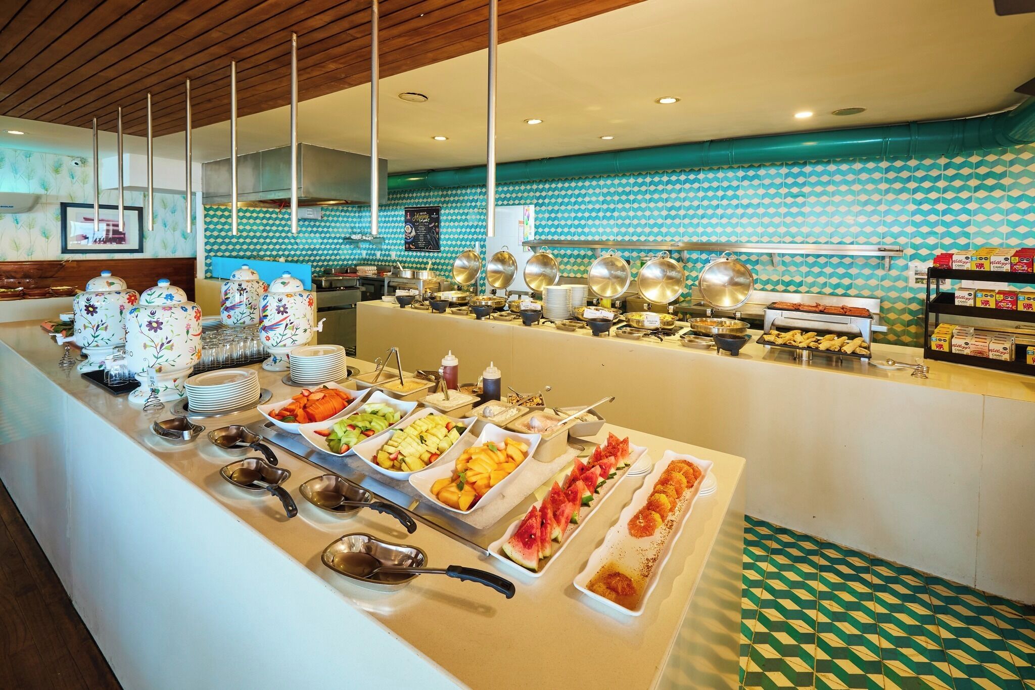 A buffet setup with various food items and serving utensils.