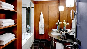 A modern bathroom with a glass-enclosed shower, wooden vanity, and a large mirror.