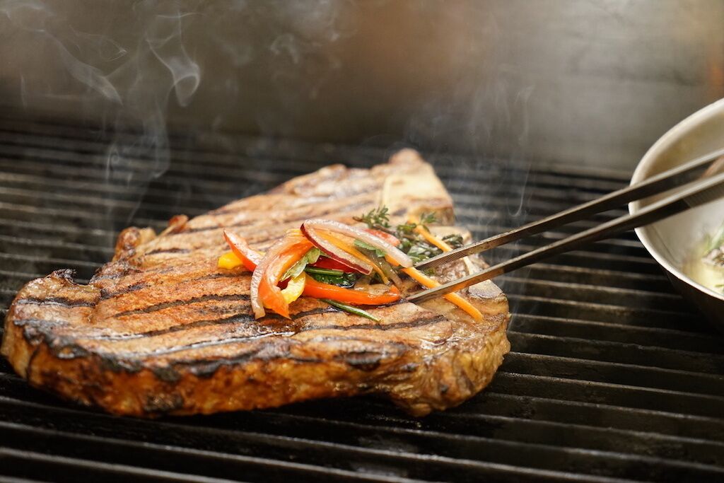 Ein Steak mit Grillstreifen und Gemüse auf einem Grill.