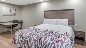 Ein modernes Hotelzimmer mit einem großen Bett, einem Schreibtisch und einem Stuhl.