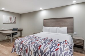 A modern hotel room with a large bed, a desk, and a chair. - Red Roof Inn Lewisville (Lewisville)