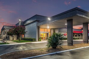 A building with a covered entrance, a Red Roof sign, and a parking lot.