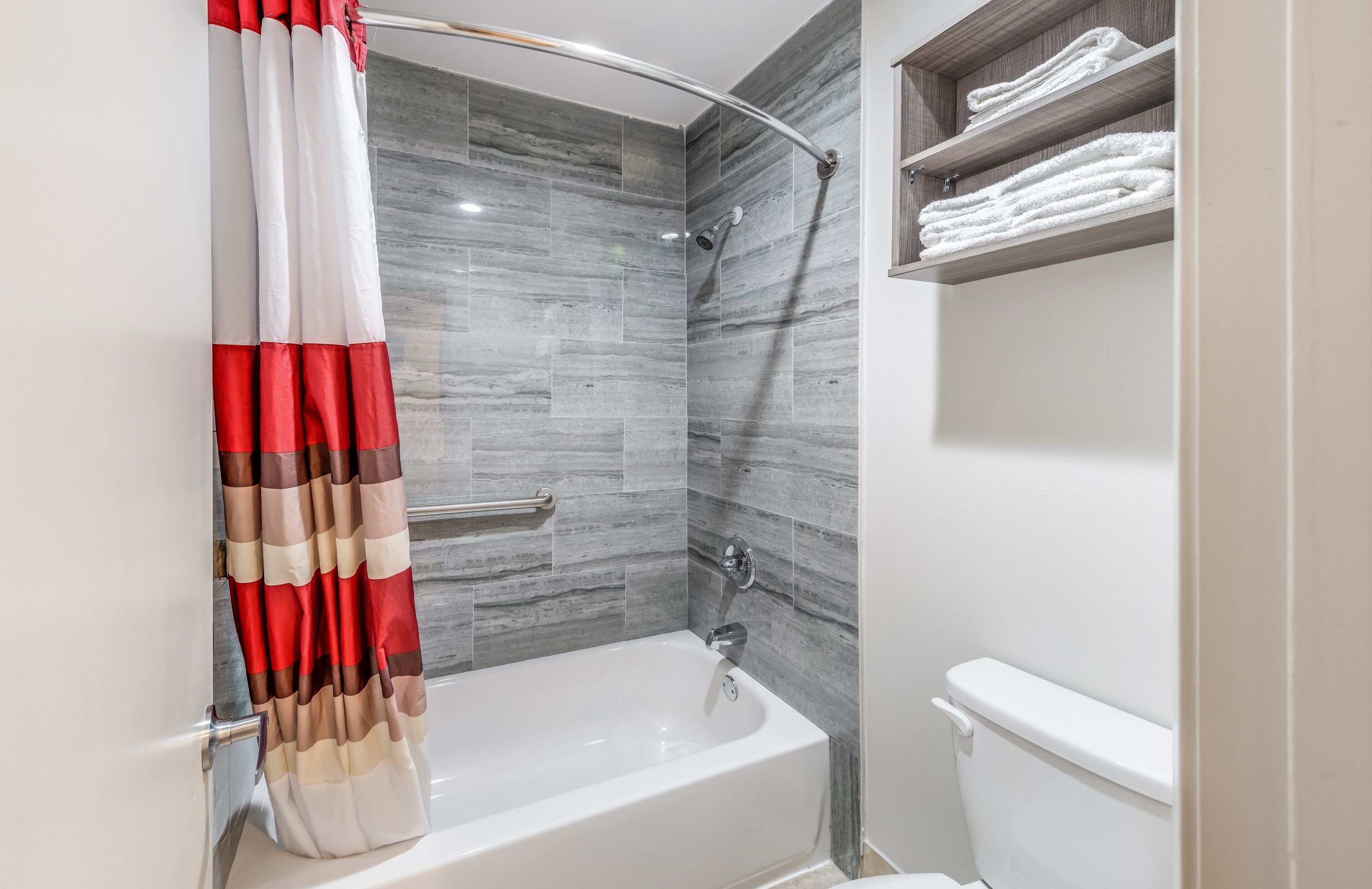 Un baño moderno con ducha, bañera y retrete.