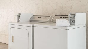 Una lavadora y secadora tipo carga frontal con un panel de control, una toalla blanca y una etiqueta de precio.