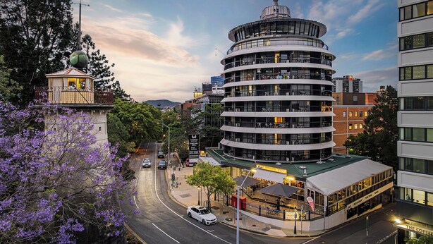 A multi-story hotel with a circular design, featuring balconies and a rooftop terrace. - Tower Mill Hotel (Spring Hill)