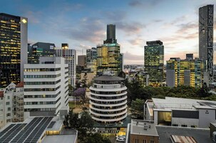 Paesaggio urbano con moderni grattacieli, un edificio circolare a più piani e una combinazione di edifici commerciali e residenziali.