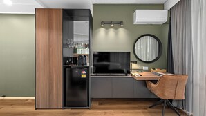 A compact kitchenette with a refrigerator, coffee maker, and glassware on shelves. - Tower Mill Hotel (Spring Hill)