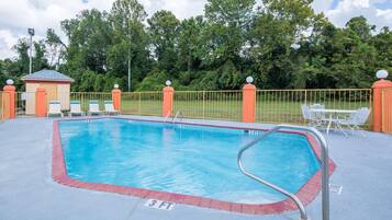 Una piscina al aire libre de temporada, sillones reclinables de piscina