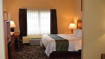 A hotel room with a bed, two bedside lamps, a desk with a chair, and a window with curtains.