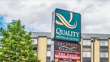 Señal de hotel que anuncia 'Quality Hotel & Suites' y 'Legends Bar & Grill'.