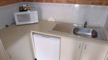 Una cocina compacta equipada con microondas, lavavajillas y fregadero.