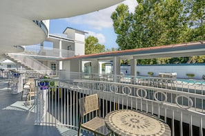 A rooftop terrace with a pool, outdoor seating, and a staircase leading to an upper level.
