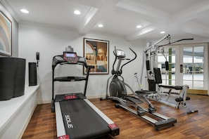 A home gym with a treadmill, elliptical, and weight machines.