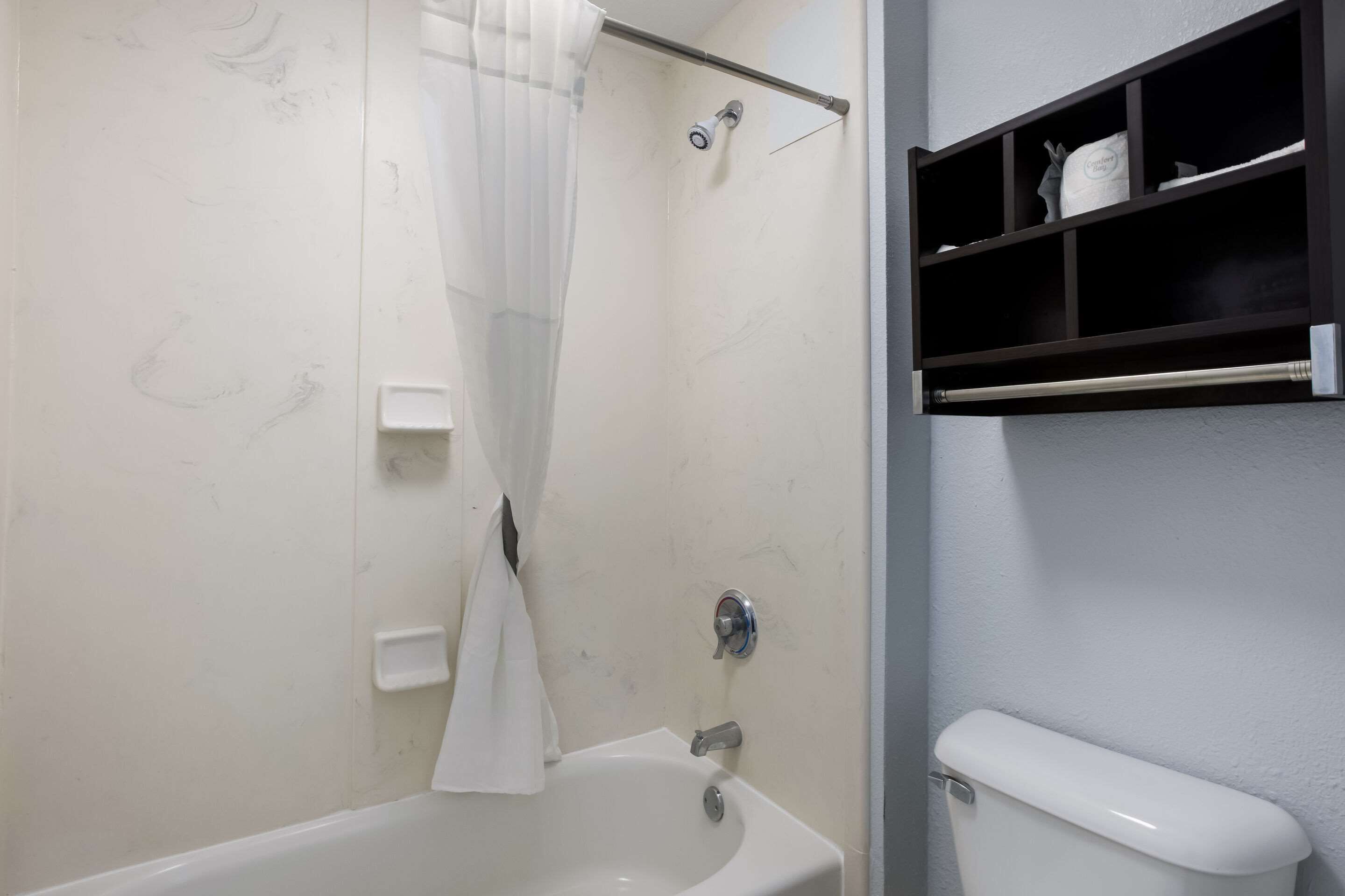 Ein Badezimmer mit Badewanne, Toilette und Ablagefläche für Toilettenartikel.