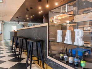 A bar area with stools, a counter, and bottles of beer. - ibis Lyon Est Bron (Bron)