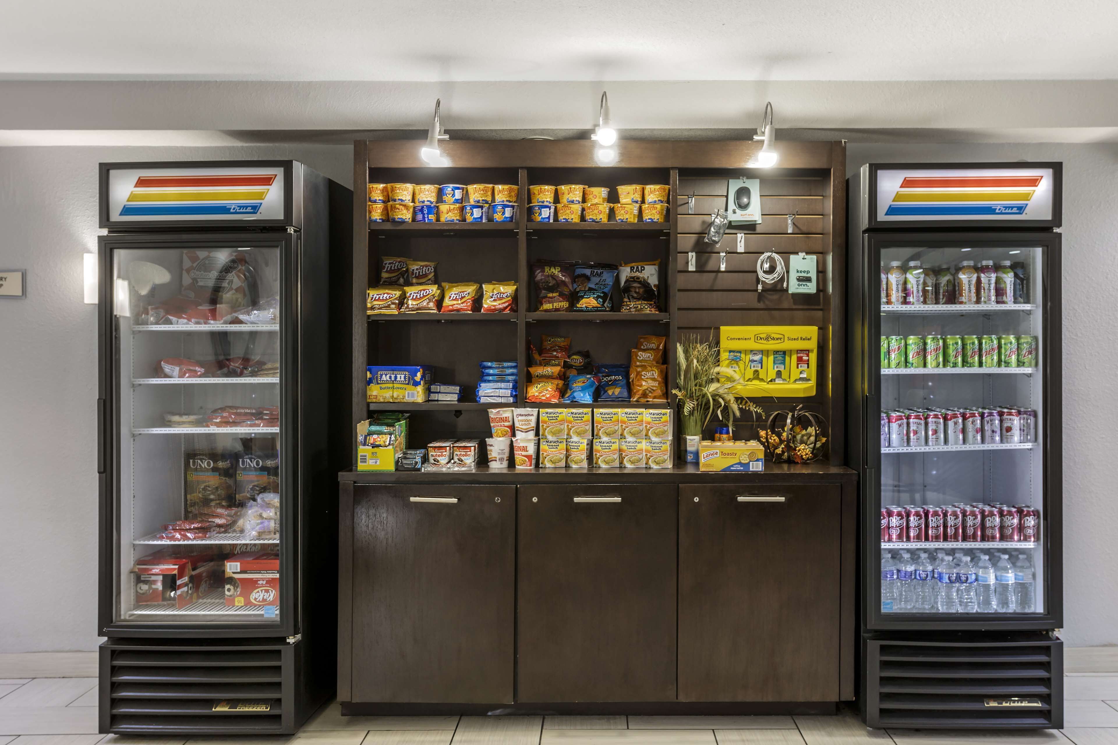 A vending machine area with snacks, drinks, and a refrigerator.