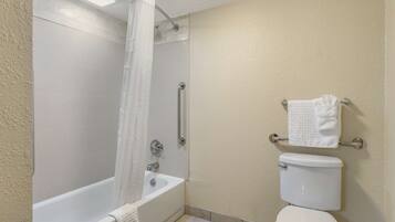Un baño con bañera, inodoro y cortina de ducha.