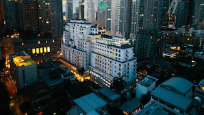 Um hotel alto com vários andares, janelas amplas e uma torre central imponente.
