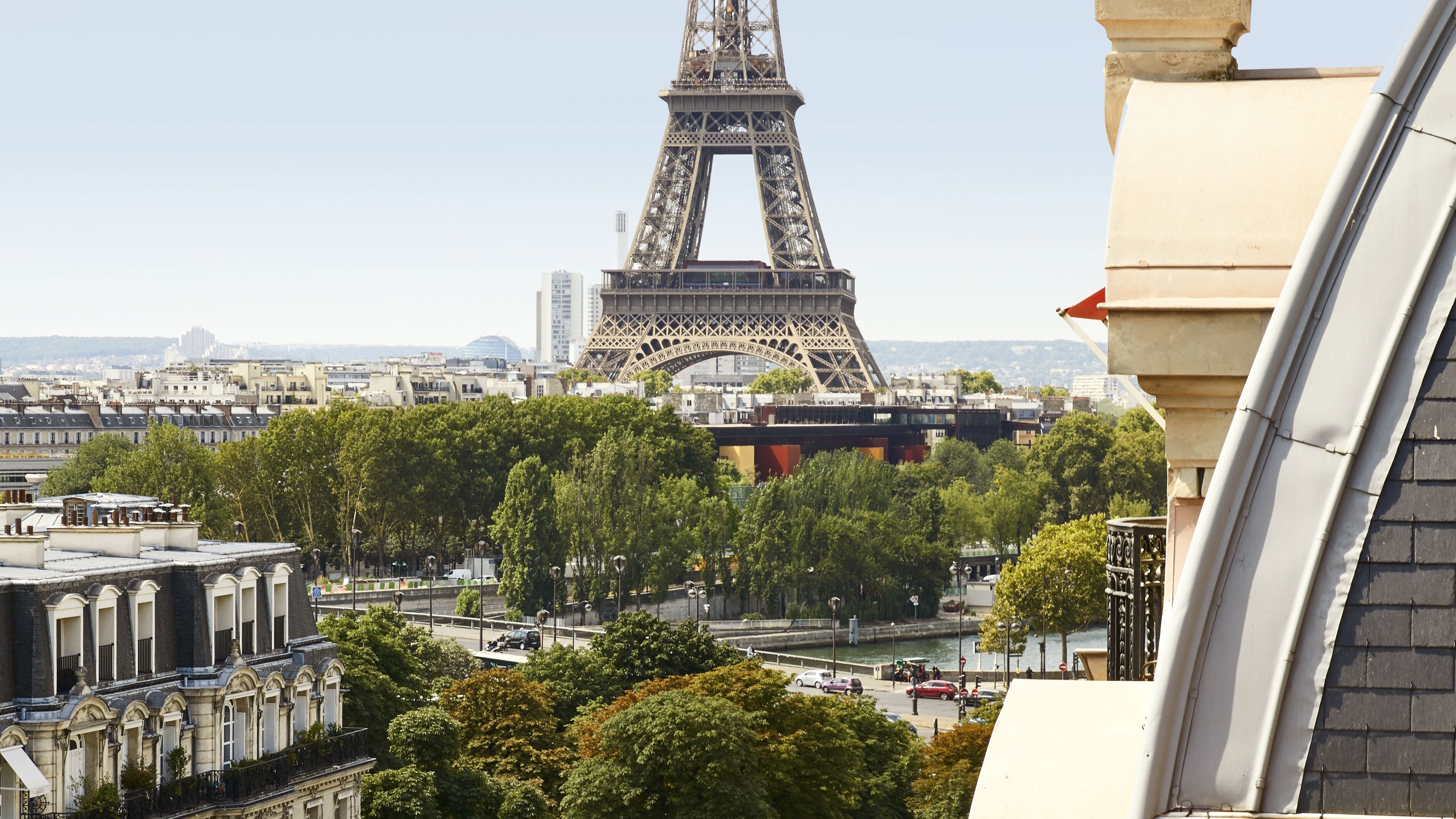 A view of the Eiffel Tower with surrounding buildings and trees.