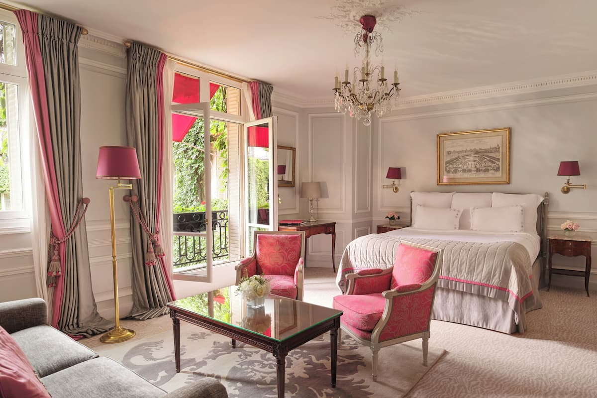 Een hotelkamer met een bed, een stoel, een tafel en een kroonluchter.