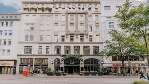 Een historisch hotel met een klassiek gevelontwerp, grote ramen en een opvallende ingang.