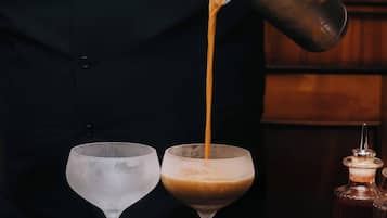 En bartender som häller upp en drink i ett glas.