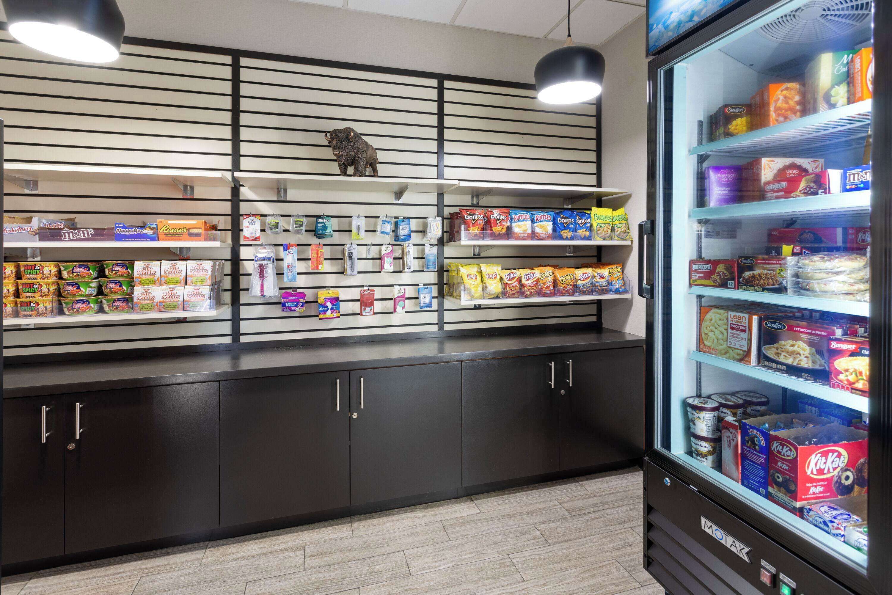 Una presentación de snacks con diversos alimentos envasados y una sección refrigerada con productos en caja.