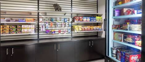 Una presentación de snacks con diversos alimentos envasados y una sección refrigerada con productos en caja.