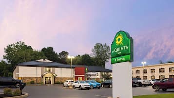 Señal de hotel con un logo de sol y el nombre Quinta Inn.