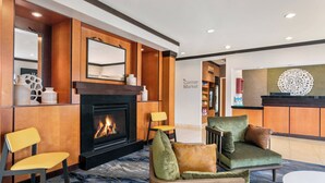 Eine Hotelhalle mit Kamin, Sitzgelegenheiten und einer Rezeption.
