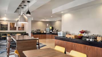 Una cocina moderna con armarios de madera, una isla central e iluminación colgante.