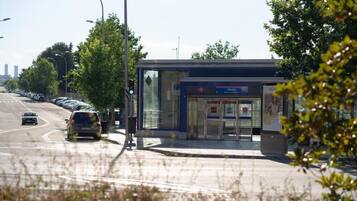 Eine Bushaltestelle mit Unterstand, eine Ampel und eine Straße mit Autos.